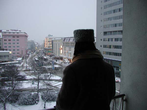 Woman on balcony in snow covered Graz